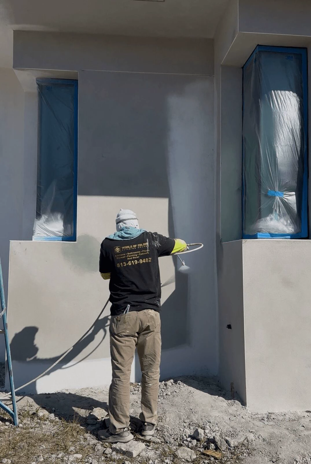 Exterior painting in Tampa, sprayer coating fresh stucco