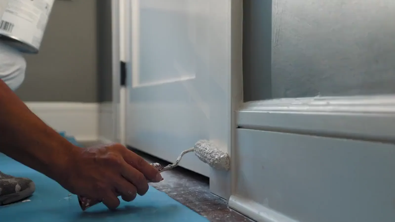 A World of Colors painter rolling fresh white paint onto interior trim in a Tampa home